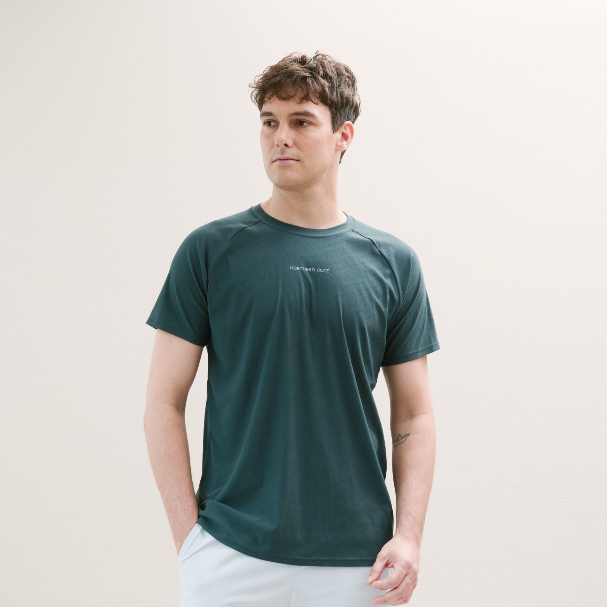 Man wearing a dark green t-shirt against a plain background