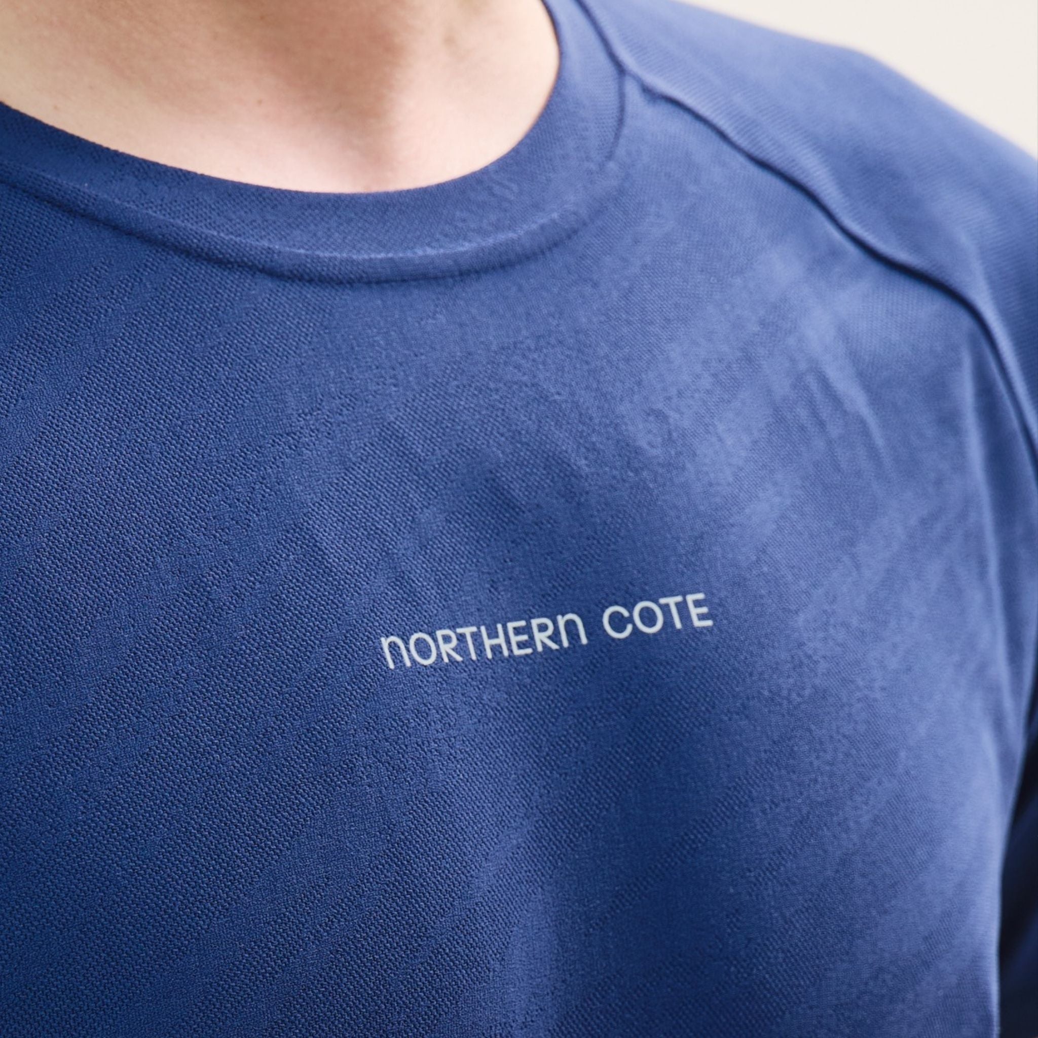 Close-up of a blue shirt with 'NORTHERN COTE' text.