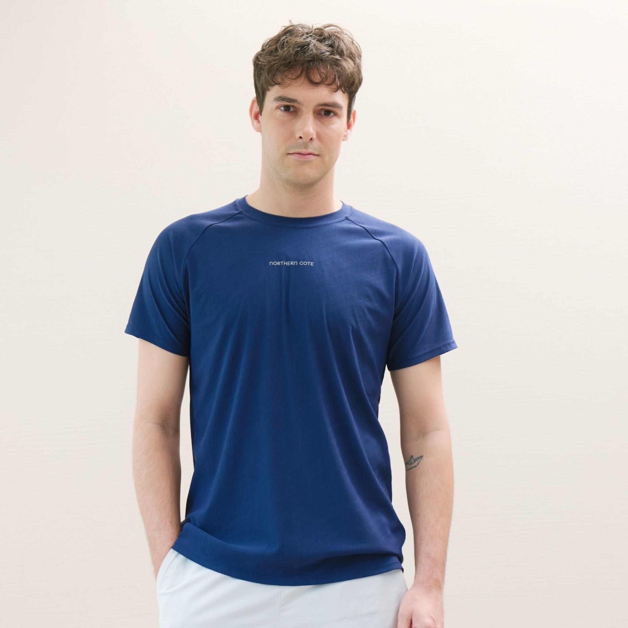 Man wearing a blue t-shirt against a plain background