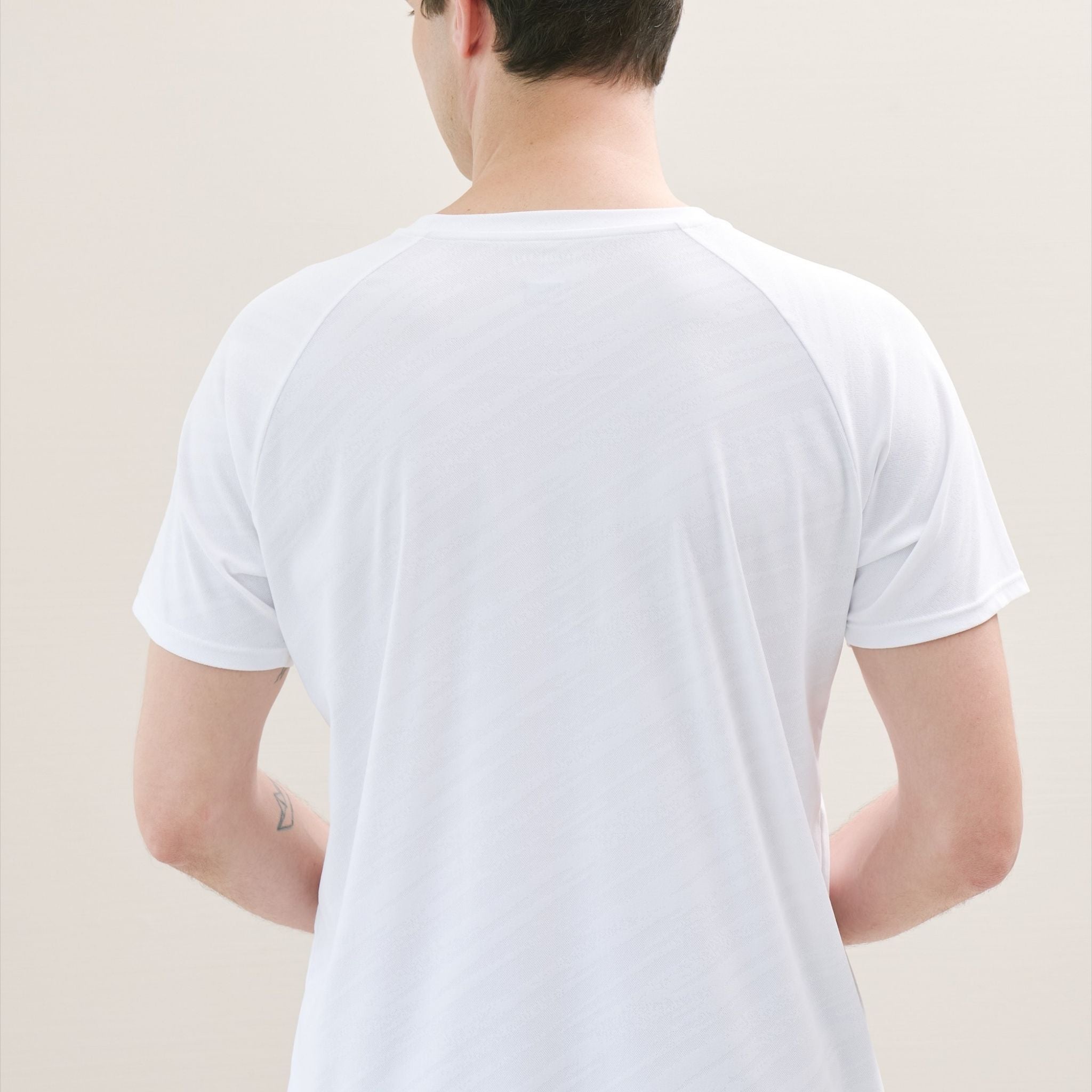 Person wearing a white t-shirt in a minimal setting