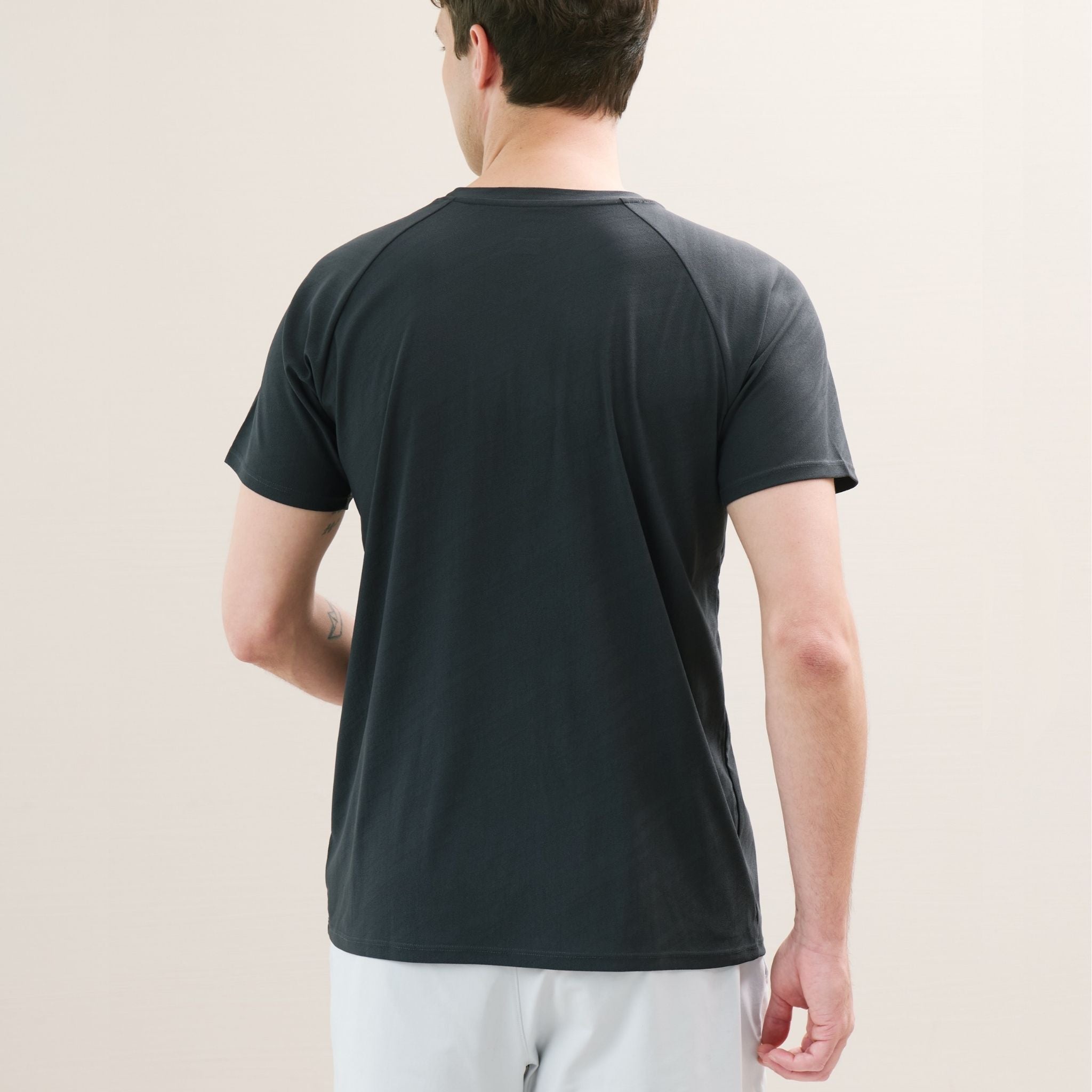 Person wearing a dark gray t-shirt against a plain background