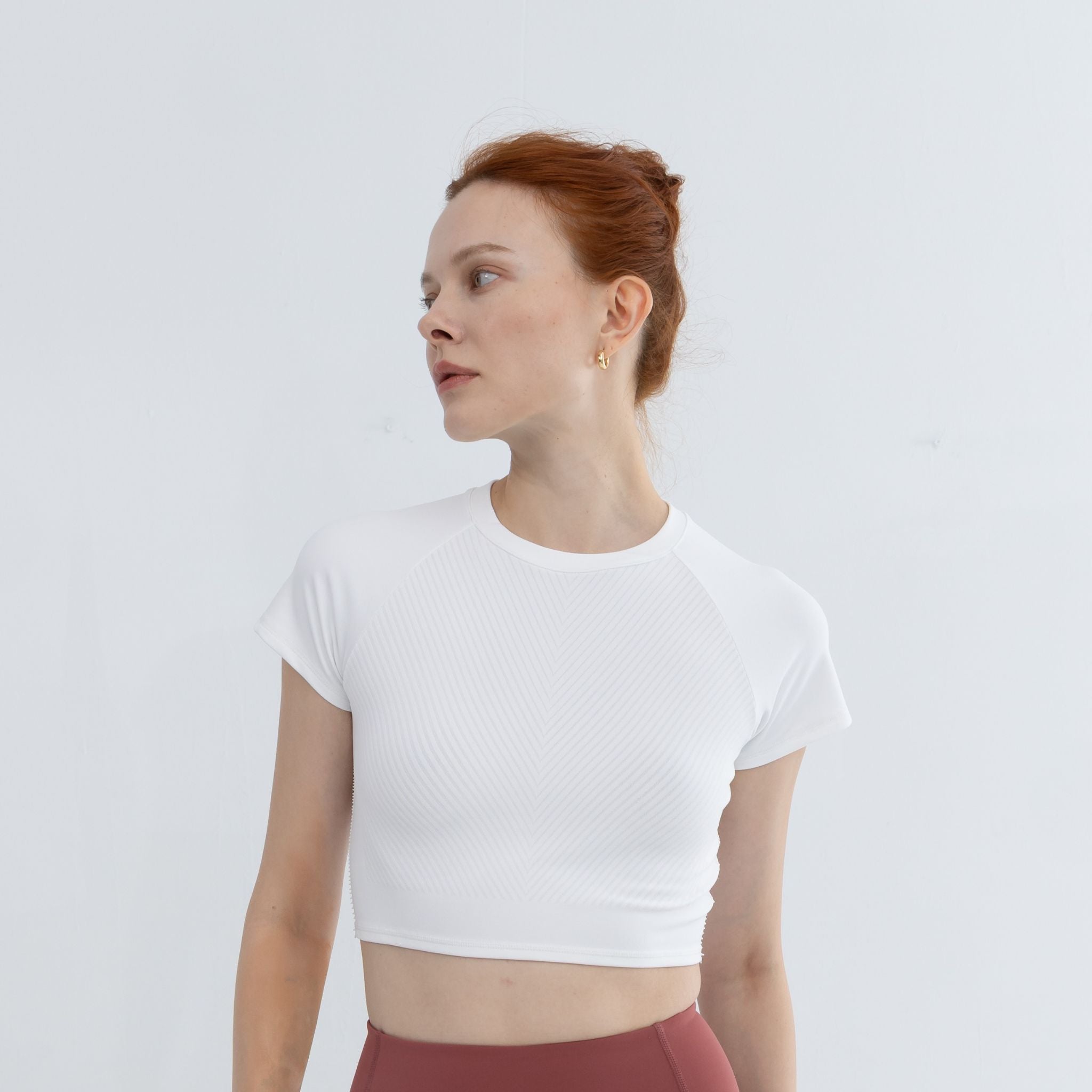 Model wearing Icy White Raglan Crop Top – front view of crop raglan shirt with raglan sleeve design