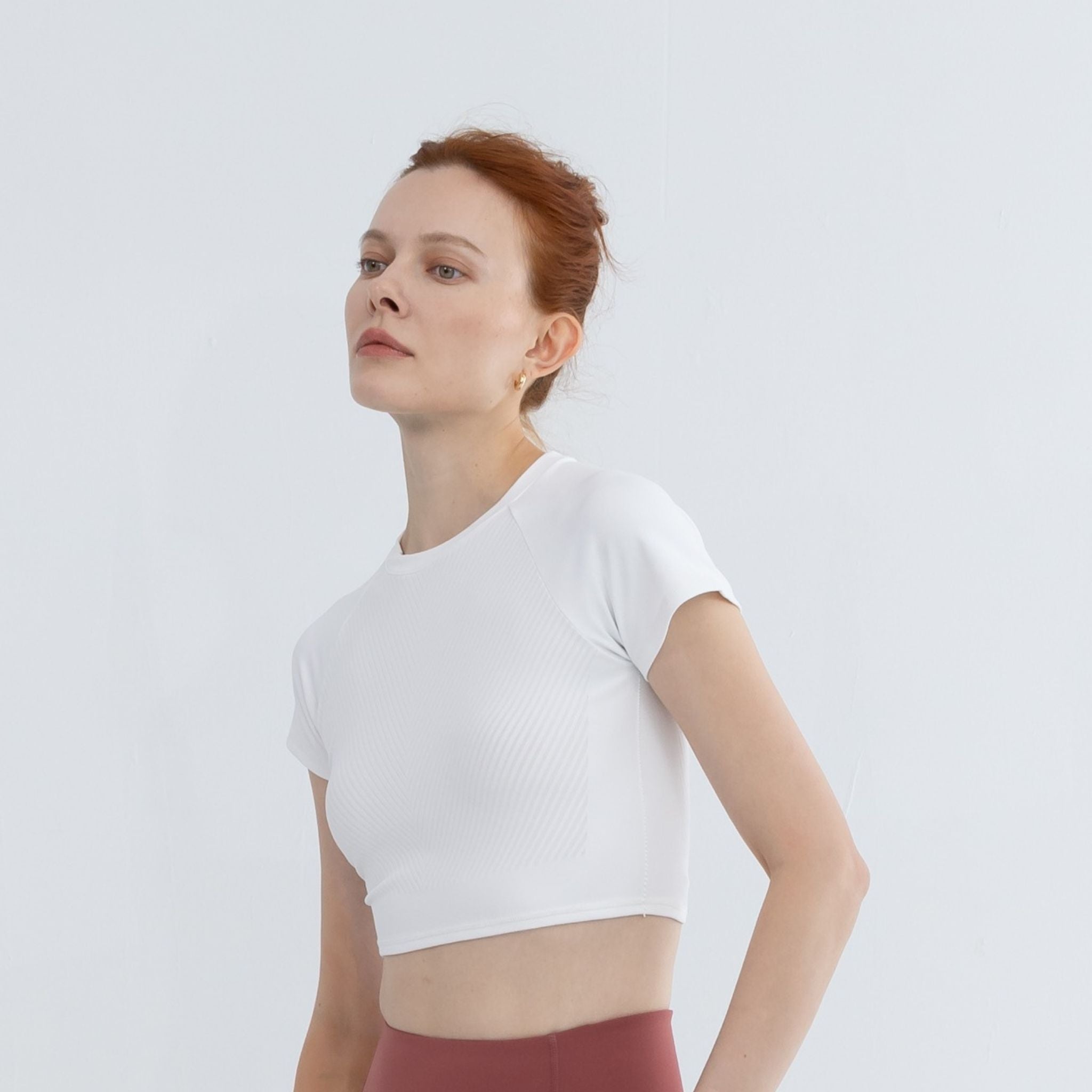 Side profile of Icy White raglan crop top with fitted silhouette and athletic raglan sleeve