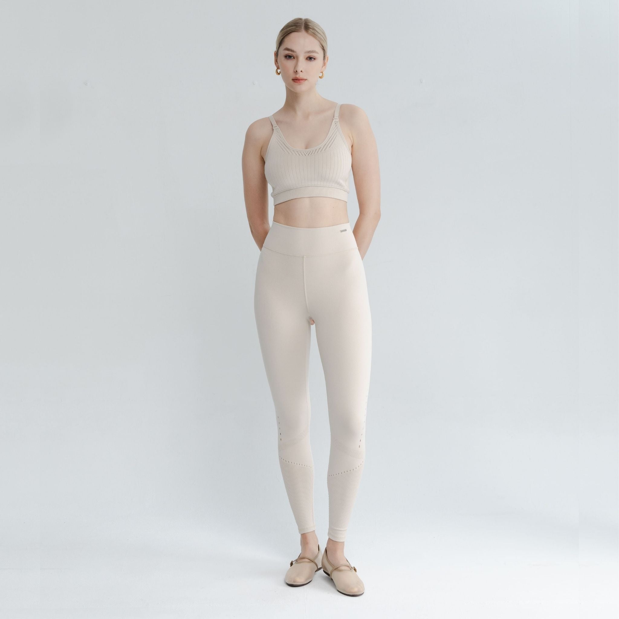 Lifestyle image of a model pairing the open style bra with matching leggings—an elegant example of open back bra styles.