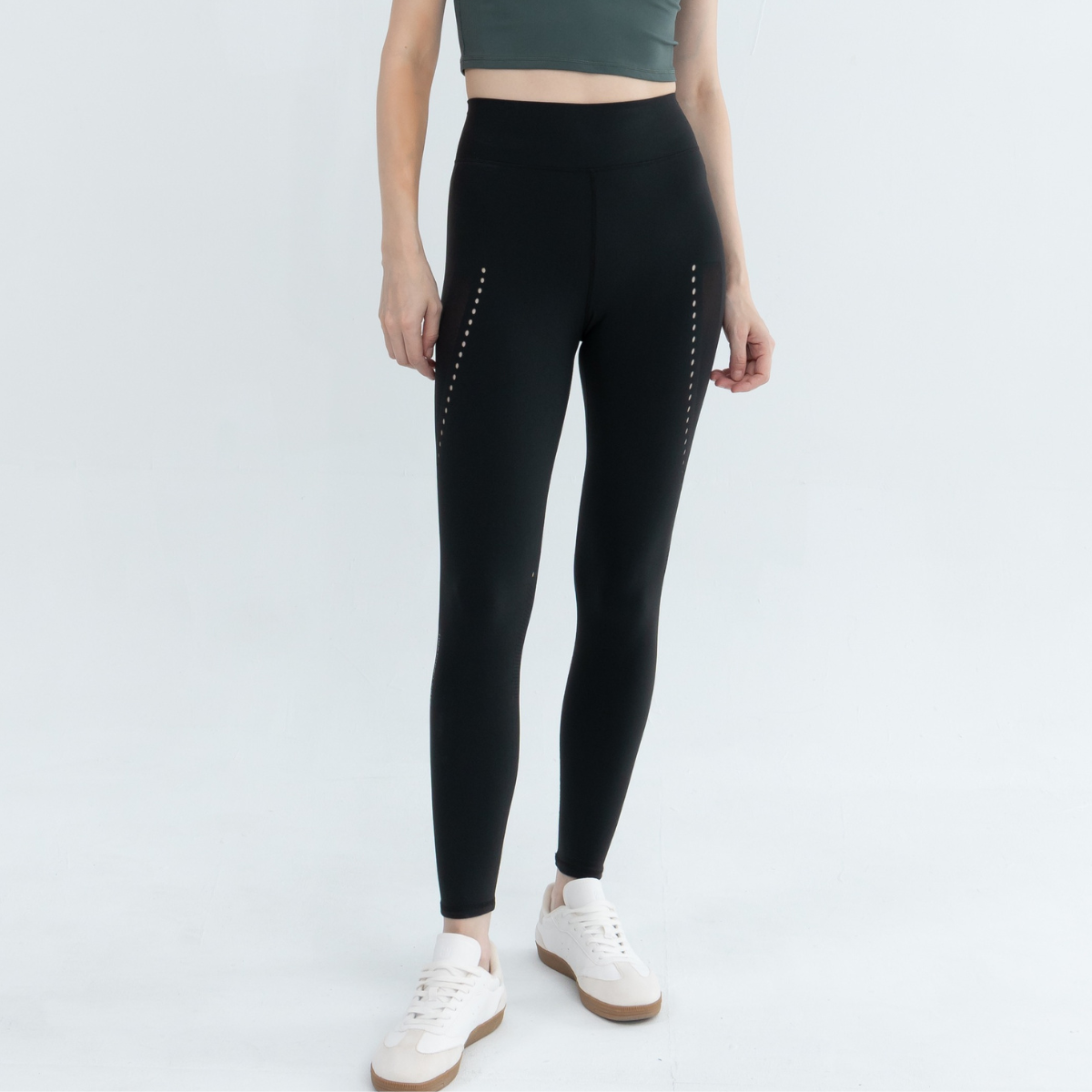 Full-length view of a person wearing black seamless leggings with a dotted pattern along the sides.