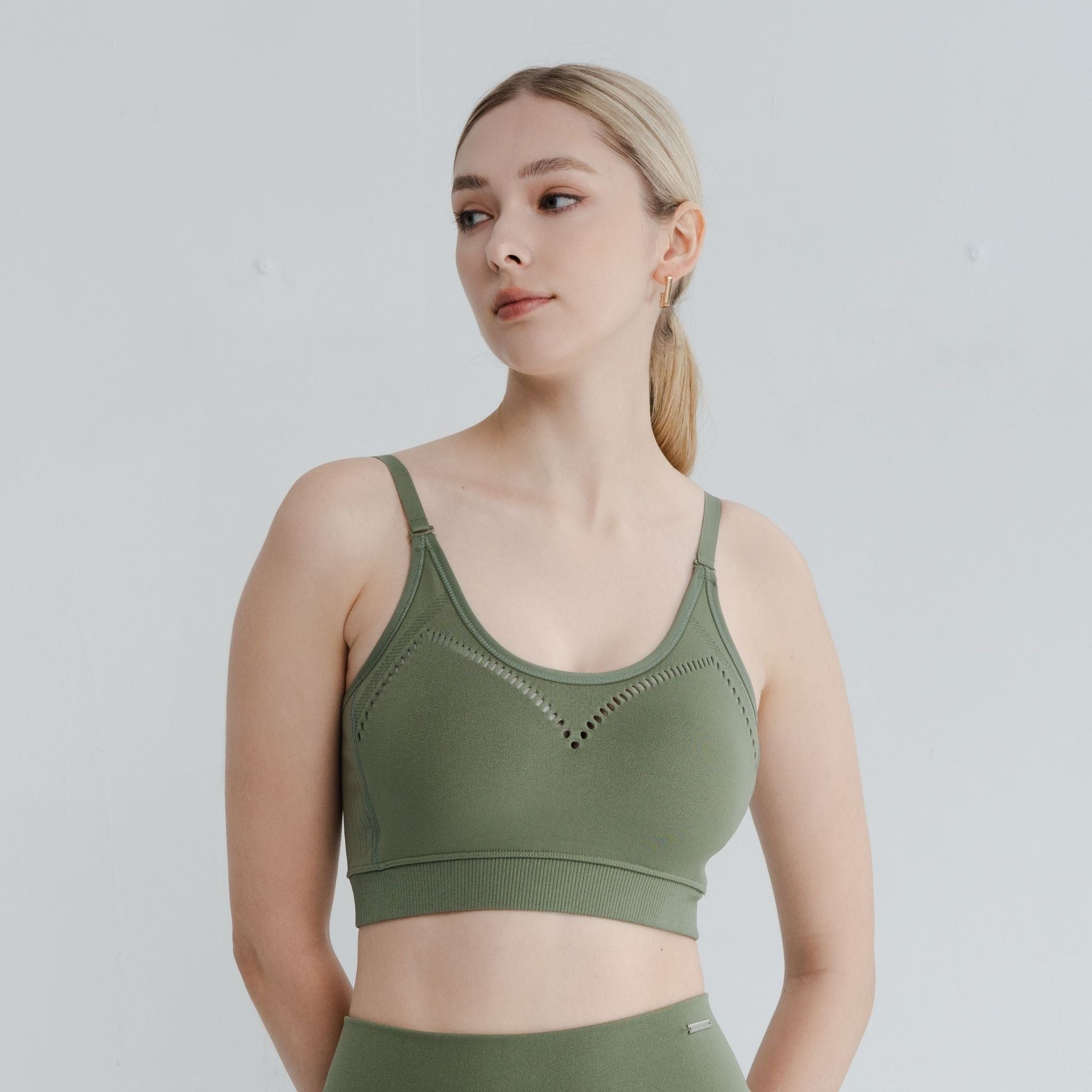 Model wearing breathable light support bra in olive green, perfect for light workouts and everyday comfort