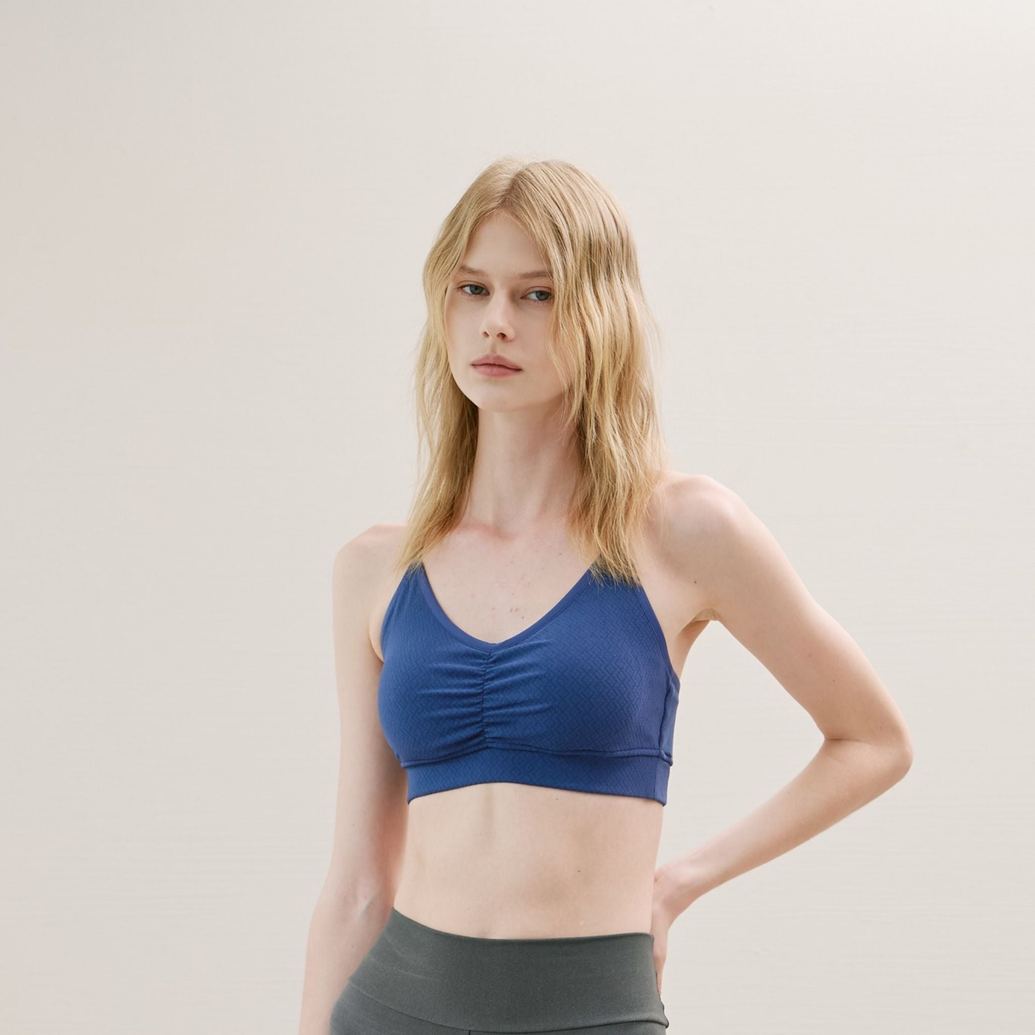 Model in blue Sports Bra with cross back design and breathable fabric.