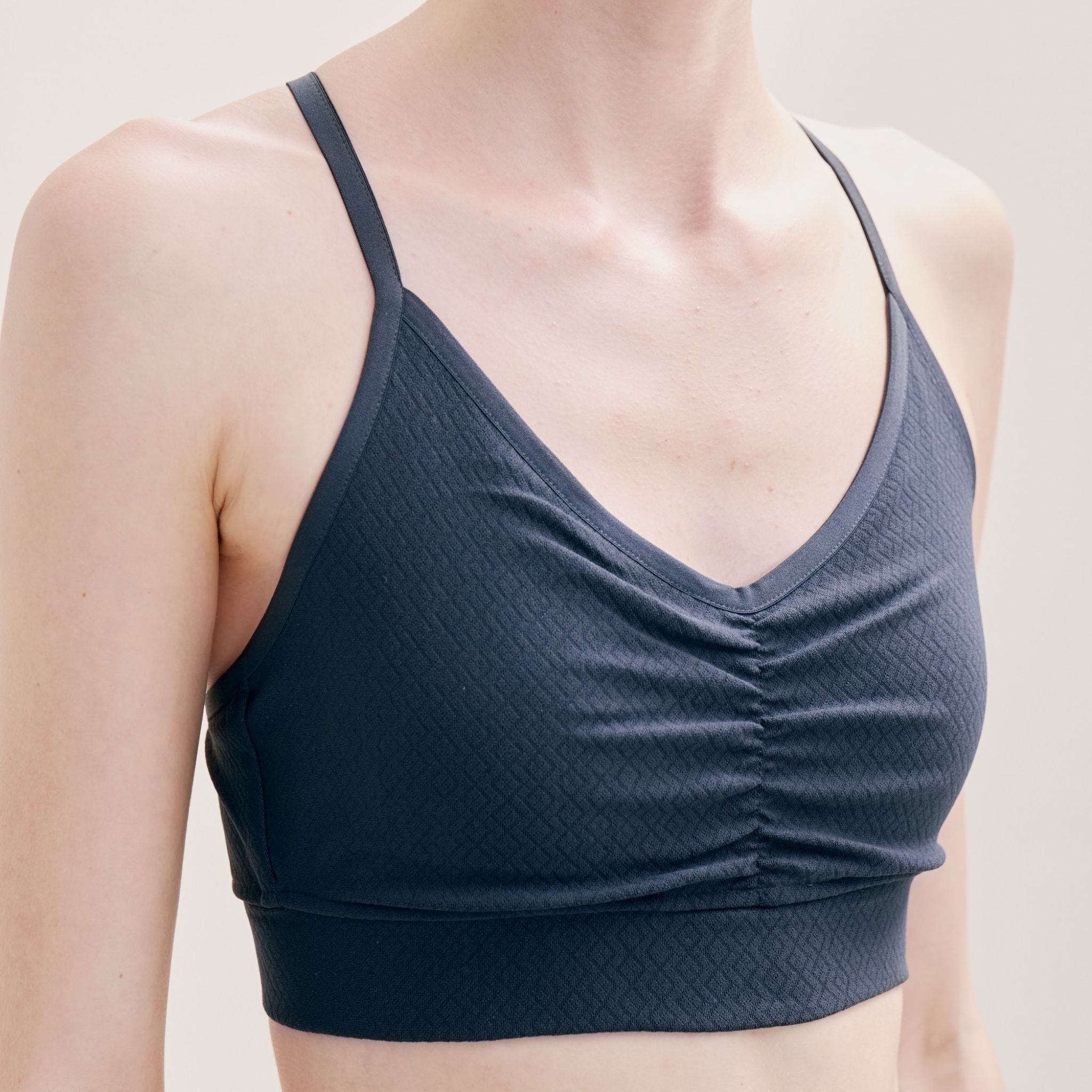 Dark gray sports bra worn by a model on a neutral background