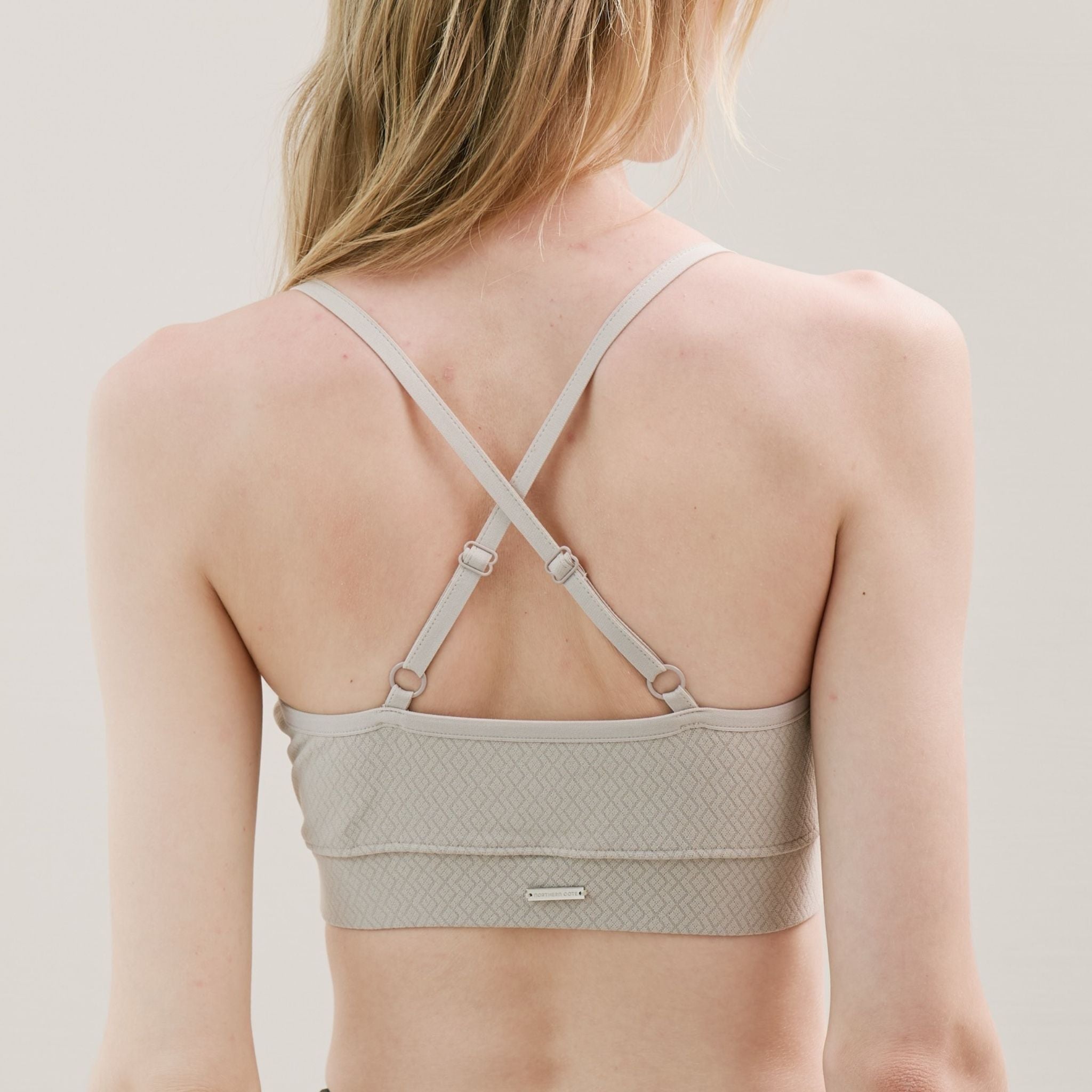 Beige bralette worn by a model on a neutral background