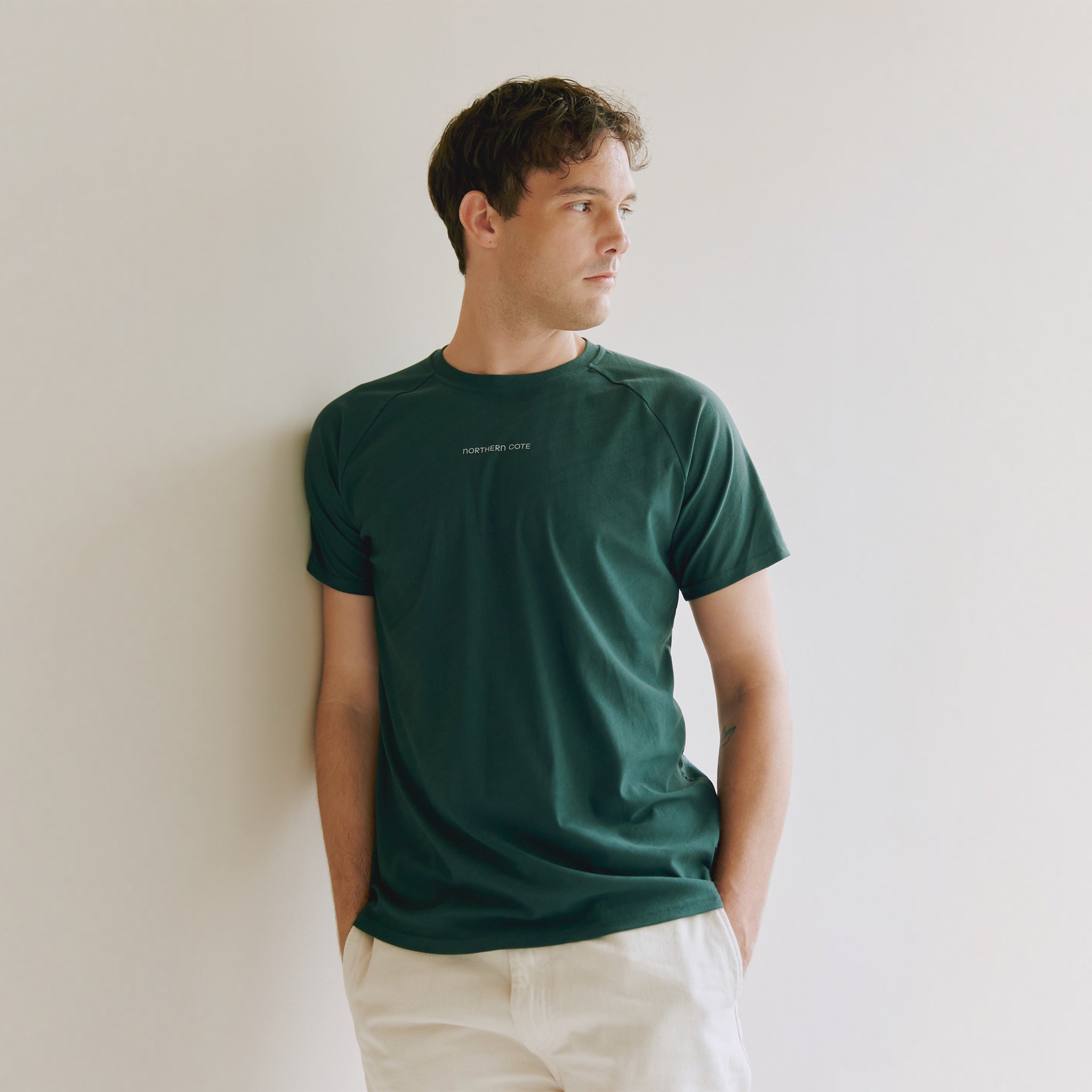 Man wearing a green t-shirt against a plain background