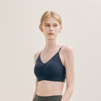 Woman wearing a black sports bra against a plain background